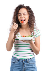 Poster - Young African-American woman with fresh salad on white background. Diet concept