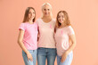 Beautiful women with pink awareness ribbons hugging on color background. Breast cancer concept