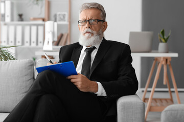 Poster - Male psychologist with clipboard video chatting in office