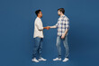 © ViDi Studio - Full body young side view two friends fun men wear white casual shirts looking camera together shaking hands meeting each other isolated plain dark royal navy blue background People lifestyle concept