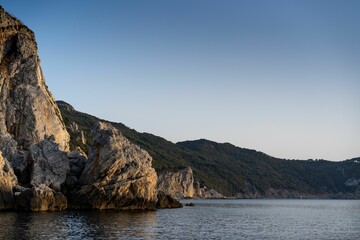 Wall Mural - Breathtaking shot of the calm sea and rocky shore during sunset, Naxos island Greece