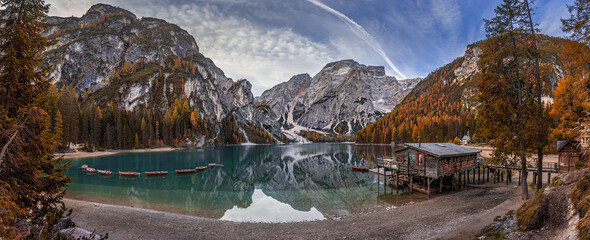 Wall Mural - Lake Braies, Italy - Panoramic view of Lake Braies (Lago di Braies) in the Italian Dolomites at South Tyrol with wooden boats, wooden cabin and Seekofel Mountain reflecting in the lake with blue sky