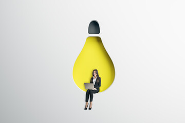 Poster - Abstract image of attractive young european businesswoman sitting on abstract hanging light bulb chair and using laptop on white background. Idea, innovation, work culture and inspiration concept.