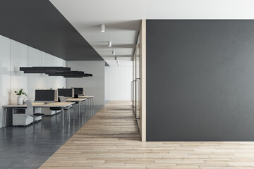 Front view on blank black wall with space for your advertising poster in sunlit eco style office with stylish minimalistic work places and wooden floor. 3D rendering, mock up