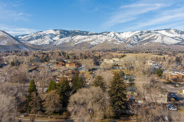 Wall Mural - Aerial view of the urban Carson City Nevada area with snow capped mountains and barren trees in early winter.