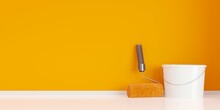 Orange Paint Roller Leaning Against Orange Wall With White Paint Bucket In Empty Room Background, Home Improvement, Renovation Or Construction Work Concept