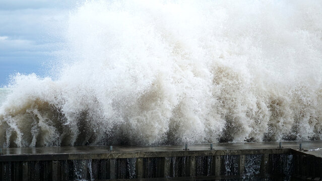 a wave crashes into a break wall along lake michigan’s shoreline at tower beach in winnetka, illinoi