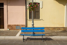 Image Of A Blue Wooden Bench In A Colorful Avenue Of An Old Town In Abruzzo Italy
