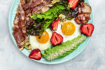 Poster - Fried egg bacon with avocado, strawberries and fresh salad. Delicious breakfast or lunch, Ketogenic, keto or paleo diet, Food recipe background. Close up