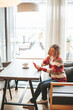 © Anna Lurye - Relaxed woman with mobile in the indoor cafe