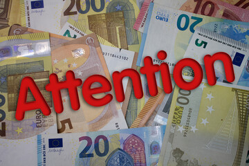Poster - Attention word with money. Paper currency background with different banknotes.