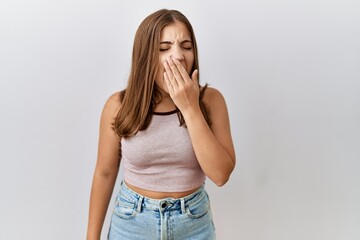 Canvas Print - Young brunette woman standing over isolated background bored yawning tired covering mouth with hand. restless and sleepiness.