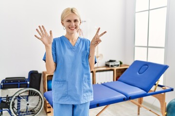 Sticker - Beautiful caucasian physiotherapist woman working at pain recovery clinic showing and pointing up with fingers number seven while smiling confident and happy.