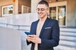 © Krakenimages.com - Young hispanic man executive smiling confident using smartphone at street