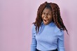 © Krakenimages.com - African woman standing over pink background angry and mad screaming frustrated and furious, shouting with anger. rage and aggressive concept.
