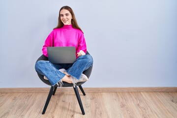 Wall Mural - Young hispanic girl working using computer laptop winking looking at the camera with sexy expression, cheerful and happy face.