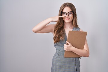 Sticker - Caucasian woman wearing glasses and business clothes pointing with hand finger to face and nose, smiling cheerful. beauty concept