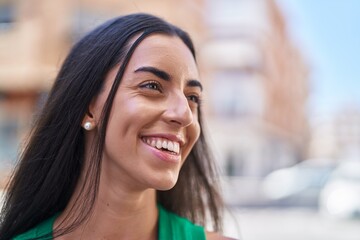 Wall Mural - Young beautiful hispanic woman smiling confident looking to the side at street