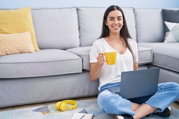 Canvas Print - Young hispanic woman using laptop drinking coffee at home