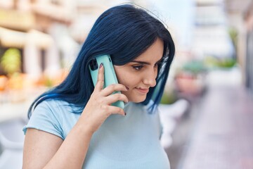 Wall Mural - Young caucasian woman smiling confident talking on the smartphone at street