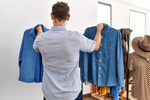 Young Hispanic Customer Man On Back View Choosing Shirt At Clothing Store.