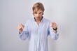 © Krakenimages.com - Caucasian man with mustache standing over white background pointing down with fingers showing advertisement, surprised face and open mouth