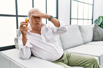 Poster - Senior man holding pills worried and stressed about a problem with hand on forehead, nervous and anxious for crisis