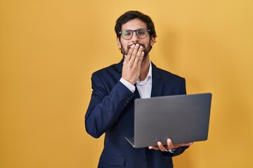 Canvas Print - Handsome latin man working using computer laptop laughing and embarrassed giggle covering mouth with hands, gossip and scandal concept