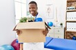 © Krakenimages.com - Young african man fired holding box with personal items at physiotherapy clinic