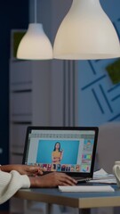 Poster - dark skin freelancer retoucher woman working overtime on laptop with photo editing software. profess