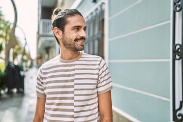 Wall Mural - Young hispanic man smiling confident at street