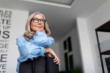 portrait of a successful business woman sitting on a chair backwards in a modern office. Business Invoice Tax Management concept