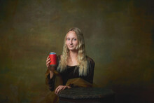 Cheers. Elegant Young Girl With Long Blonde Hair Wearing Medieval Dress Like Mona Lisa Replica Over Dark Vintage Background. Comparison Of Eras Concept.