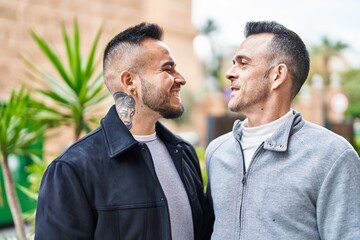 Two men couple smiling confident standing together at street