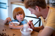 © zinkevych - Dad and son sitting at the table and eating breakfast