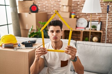 Canvas Print - Young hispanic man moving to a new home looking at the camera blowing a kiss being lovely and sexy. love expression.