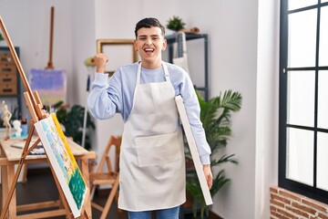 Wall Mural - Non binary person at art studio screaming proud, celebrating victory and success very excited with raised arms