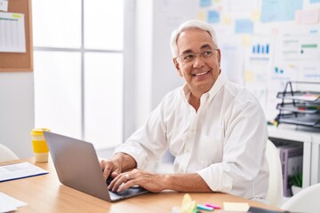 Canvas Print - Middle age grey-haired man business worker using laptop working at office