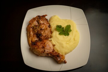 Wall Mural - Close-up shot of a fried chicken thigh and mashed potatoes on a plate