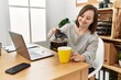© Krakenimages.com - Brunette woman with down syndrome drinking a cup of coffee at business office