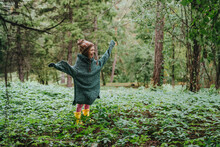 Happy Girl In Oversized Sweater Standing Amidst Forest