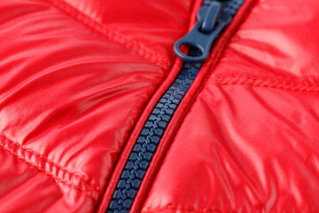 Wall Mural - Closed blue zipper on red winter down jacket closeup.