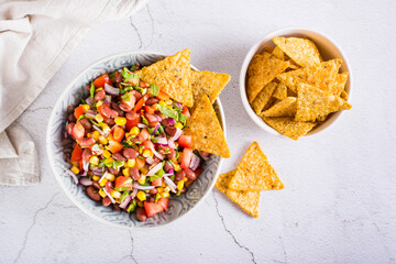 Mexican vegetable salad cowboy caviar and nachos in a bowl on the table. Top view