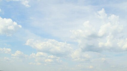 Wall Mural - Slowly moving cumulus clouds against a blue sky. Calm, peaceful landscape in summer weather. White fluffy clouds.