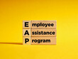 Wooden cubes with the the abbreviation EAP employee assistance program.