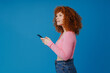 © Drobot Dean - European puzzled woman with red curly hair using mobile phone