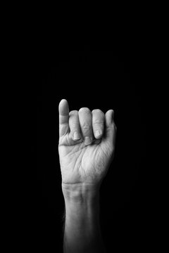 Hand demonstrating the Japanese sign language letter 'I' or 'ぃ' with copy space