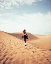 Anonymous Woman Walking On Dune