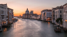 Sunrise  Over The Grand Canal, In Venice, Italy, Looking Towards The Majestic Basilica Di Santa Maria Della Salute. Long Exposure To Smooth Out The Water