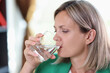 Thirsty woman drinking water from transparent glass